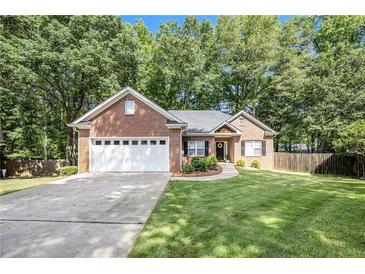 Charming brick home featuring a manicured lawn, two-car garage, and welcoming front entrance at 6788 Oakhurst Court Ct, Douglasville, GA 30134