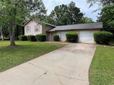 Charming single-story home featuring a two-car garage and a well-maintained front yard with mature trees at 3429 Timbercreek Dr, Lawrenceville, GA 30044