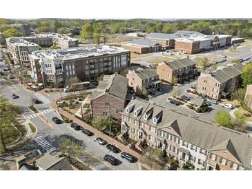 An aerial view showcases the neighborhood, with tree-lined streets, sidewalks, and brick townhomes at 310 Rose Garden Ln, Alpharetta, GA 30009
