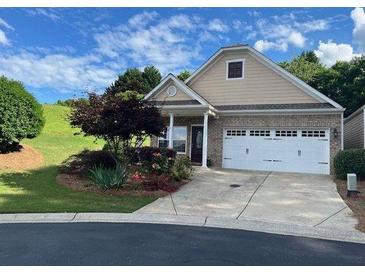 Charming single-story home featuring manicured landscaping and a two-car garage at 407 Aerif Place Pl, Woodstock, GA 30188