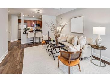 Bright living room with contemporary decor, plush seating, and a view to the kitchen with breakfast bar at 325 E Paces Ferry Ne Rd # 410, Atlanta, GA 30305