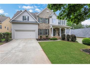 Charming home with a well-manicured lawn, beautiful landscaping, and a two-car garage at 3980 Suwanee Place Dr, Suwanee, GA 30024