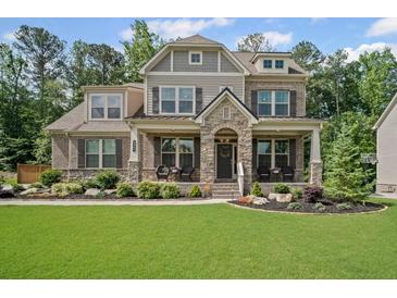 Charming two-story home with a manicured lawn, stone accents, and a welcoming front porch at 4960 Norman Ct, Cumming, GA 30040