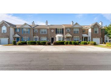 Row of two-story brick townhomes with manicured landscaping and individual entrances at 2727 Parkway Trl, Lithonia, GA 30058