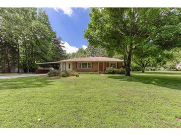 Ranch-style home with mature trees and a covered carport on a spacious lot at 4545 Gaydon Rd, Powder Springs, GA 30127