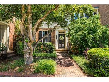 Charming brick townhome featuring a welcoming brick pathway and lush landscaping leading to the front door at 615 Pinetree Dr, Decatur, GA 30030