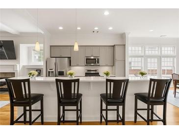 Bright eat-in kitchen features stainless steel appliances, gray cabinets, pendant lights, and countertop dining at 1258 Dekalb Ne Ave # 112, Atlanta, GA 30307