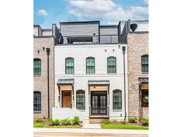 Charming townhome with a white painted brick exterior and a rooftop deck, perfect for city living at 338 Sugarview Rd, Sugar Hill, GA 30518