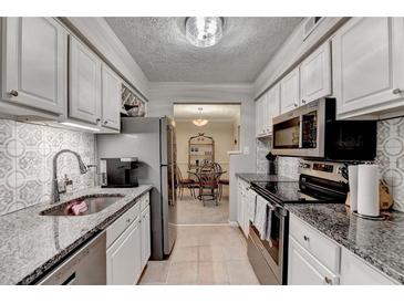 Galley kitchen features granite countertops and stainless steel appliances at 5149 Roswell Rd # 7, Atlanta, GA 30342
