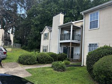 Beige two-story condo with black balcony railing and manicured front lawn at 621 Ridge Creek Dr, Clarkston, GA 30021