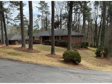 Charming brick home nestled among mature trees with a well-maintained front yard at 1376 Woodbine St, Marietta, GA 30062
