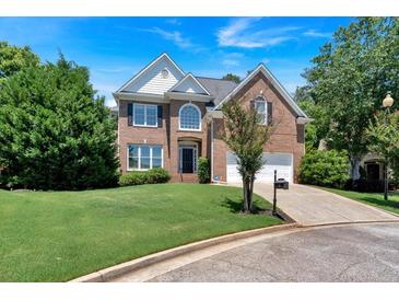 Charming two-story brick home featuring a well-manicured lawn, two-car garage, and classic architectural details at 3400 Dencrest Se Ct, Smyrna, GA 30080