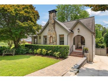 Charming home featuring a stone chimney, brick walkway, and well-manicured landscaping at 1748 N Pelham Ne Rd, Atlanta, GA 30324