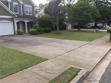 Suburban home with a driveway, manicured lawn, and mature trees in a well-kept neighborhood at 3639 Cape Ln, Conyers, GA 30013