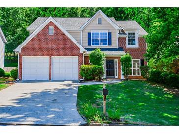 Charming two-story brick home with manicured lawn and attached two-car garage at 136 Parkstone Way, Marietta, GA 30066