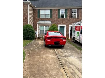 Brick townhome with driveway, green door, and a U-Haul moving truck nearby at 4612 Grand Central Pkwy, Decatur, GA 30035