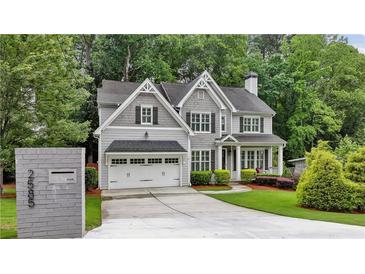 Beautiful two-story home featuring a two-car garage, gray siding, and professionally landscaped front yard at 2585 Drew Valley Ne Rd, Brookhaven, GA 30319