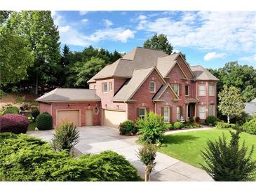 Stunning two-story brick home with a meticulously maintained lawn and three-car garage at 3332 Heathchase Ln, Suwanee, GA 30024
