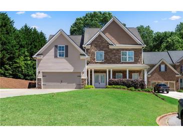 Charming two-story home with a stone and siding exterior and well-manicured lawn at 3415 Kenyon Creek Nw Dr, Kennesaw, GA 30152
