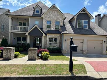 Charming home featuring a two-car garage, well-manicured landscaping, and a mix of stone and siding exterior at 2657 Gray Mill Way, Loganville, GA 30052