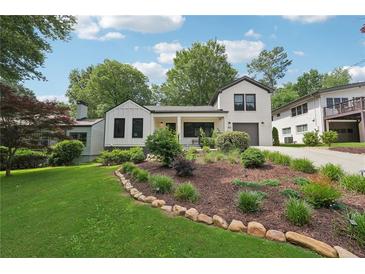 Charming home with landscaped front yard, rock border, and lush green grass at 1815 Coventry Rd, Decatur, GA 30030