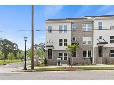 Modern townhome exterior with brick and white siding, large windows, and well-maintained landscaping at 2535 Astaire Ct, Atlanta, GA 30318