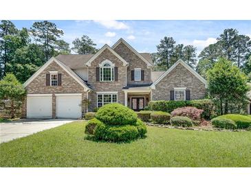 Charming brick home with a well-manicured lawn and lush landscaping creates excellent curb appeal at 543 Serene Waters Trl, Jonesboro, GA 30236