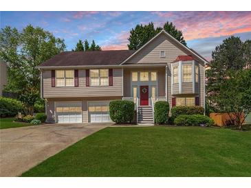Charming two-story home with a well-manicured lawn, attached garage, and a welcoming front porch at 2577 Abbotts Glen Nw Dr, Acworth, GA 30101