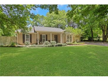 Charming ranch-style home featuring a well-manicured lawn and inviting front porch at 1605 Saddlecreek Rd, Auburn, GA 30011