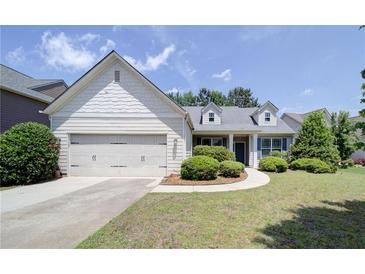 Charming single-Gathering home featuring a manicured lawn and attached two-car garage at 1575 Parkside Village Dr, Cumming, GA 30040