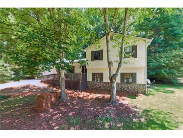 Charming home featuring a inviting front porch, complemented by a well-maintained lawn and mature shade trees at 2031 Dennis Pl, Buford, GA 30519
