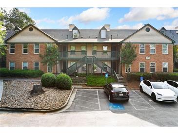 Two-story condo complex showing parking lot and exterior elevation with stairs to the units at 717 Beaufort Cir, Duluth, GA 30096