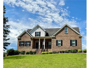 Charming brick two-story home featuring a well-manicured lawn and a welcoming front porch at 8967 Midlothian Ct, Winston, GA 30187