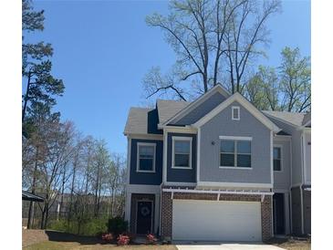 Charming two-story home with brick accents and a well-manicured front yard under a clear sky at 201 Jonquil Spring Rd, Woodstock, GA 30188