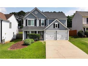 Charming two-story home boasts a manicured lawn and a two-car garage, creating a welcoming curb appeal at 3200 Binghampton Ln, Lawrenceville, GA 30044