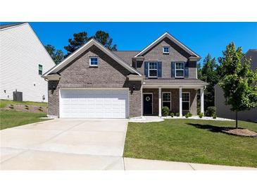 Charming two-story brick home with a well-manicured lawn and a two-car garage at 5440 Wheeler Ridge Rd, Auburn, GA 30011