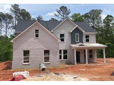 Charming two-story home with light brick, gray shingles, and covered front porch at 3292 Mill Forest Dr, Conyers, GA 30094