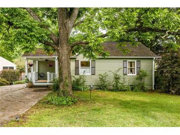 Charming home featuring green siding, a covered porch, and a lush, mature tree in the front yard at 1682 Grace Se St, Atlanta, GA 30316