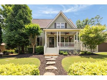 Charming home featuring a welcoming front porch with ceiling fans and landscaped front yard at 4530 Upland Court, Cumming, GA 30040