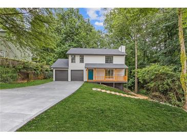 Charming two-story home featuring a welcoming porch, a two-car garage, and a well-manicured lawn at 2599 Willow Creek Dr, Duluth, GA 30096