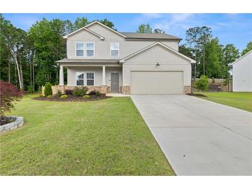 Charming two-story home with a manicured lawn and a two car garage at 272 Broadstone Blvd, Acworth, GA 30101