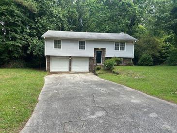 Charming two-story home featuring a two-car garage and well-maintained lawn at 6956 Kimberland Gardens Ln, Lithonia, GA 30058