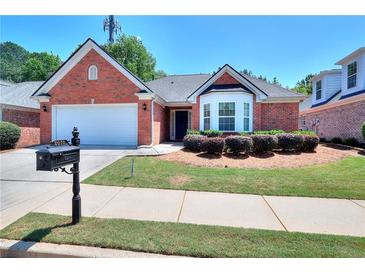 Charming single-story red brick home with a well-manicured lawn and attached two car garage at 2010 Hickory Station Cir, Snellville, GA 30078