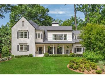 Stunning white brick home with manicured lawn and classic architectural details at 3894 Land O Lakes Ne Dr, Atlanta, GA 30342