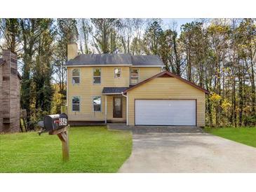 Charming yellow two-story home with a well-manicured lawn and attached garage, perfect for Gathering living at 3845 Springleaf Ct, Stone Mountain, GA 30083