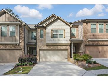 Beautiful townhome with attached garage, brick and siding facade, and manicured landscaping at 1360 Sugar Glen Ct, Lawrenceville, GA 30044