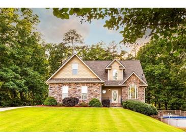 Charming stone and shingle home with manicured lawn and mature trees at 200 Scouts Ridge Dr, Covington, GA 30016