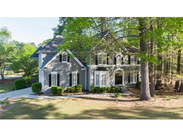Charming gray two-story home with black shutters, lush landscaping, and a well-manicured front lawn at 251 Waterford Cove Dr, Suwanee, GA 30024