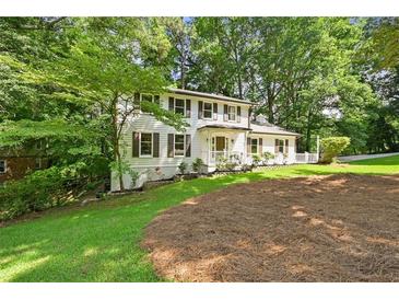 Charming two-story home with white siding, dark shutters, and a beautifully landscaped front yard at 2935 Leafwood Se Dr, Marietta, GA 30067