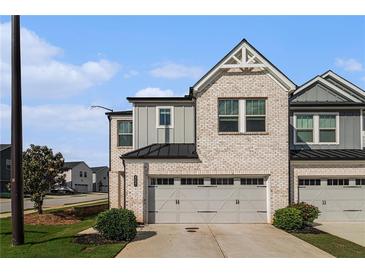 Charming two-story townhome with a brick and gray facade, two-car garage, and well-maintained landscaping at 4627 Piston Sw Jct, Mableton, GA 30126